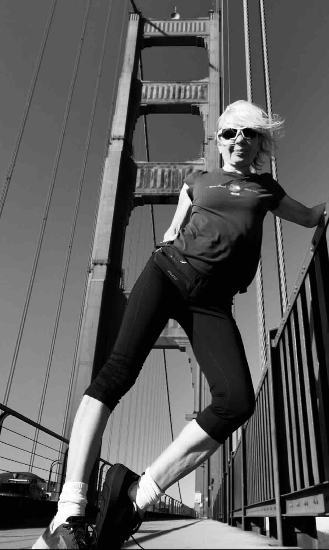 Lena Faber running across the Golden Gate Bridge in San Francisco, California during sunrise.